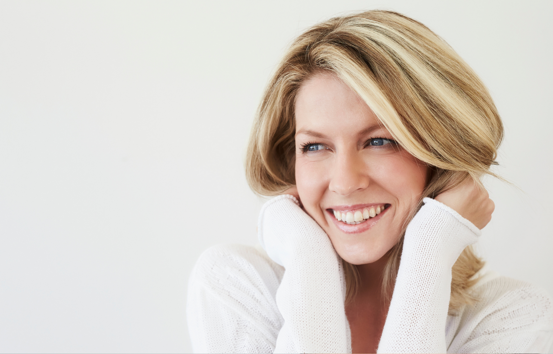 Blonde hair woman smiling wearing long sleeve white shirt - Anti wrinkle treatment perth